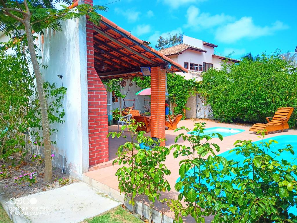 a house with a patio and a swimming pool at Residencial Mar Da Galileia in Porto Seguro