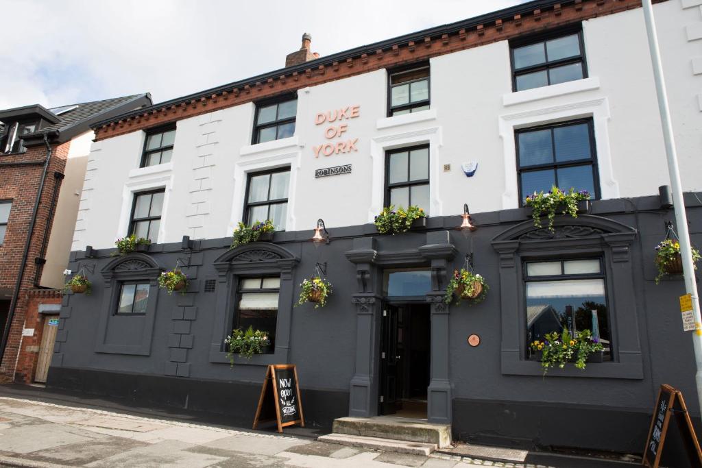 um edifício branco com um sinal que lê a vibração de Oxford em Duke Of York em Hazel Grove