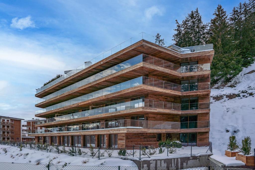 a large building with snow on the ground at Sport Club Residences & Spa in Crans-Montana