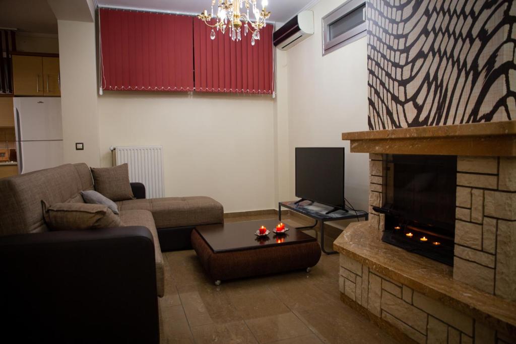 a living room with a couch and a fireplace at g.home in Tríkala