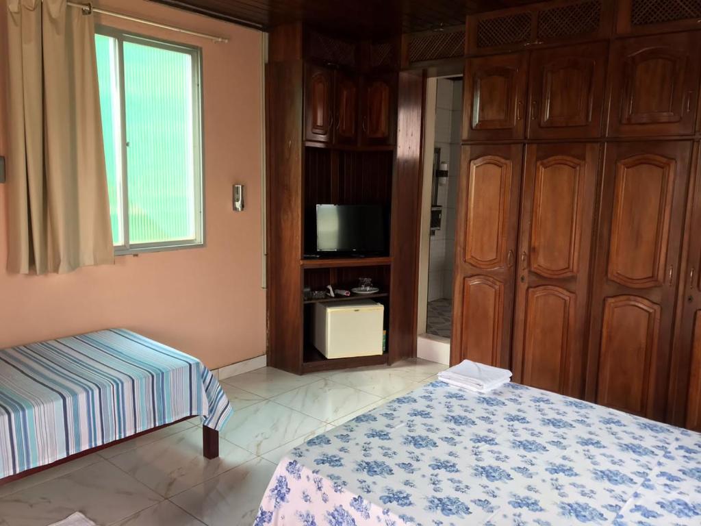 a bedroom with a bed and a tv and a window at Apartamento Suíte em Soure. in Soure