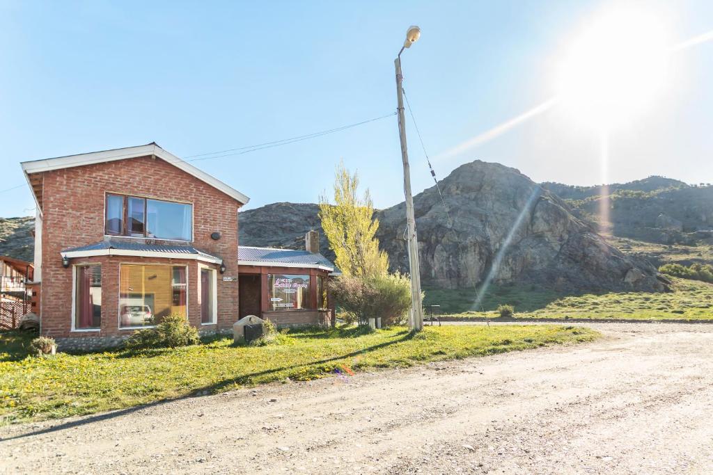 a brick house on the side of a dirt road at Hostel Luna Country in El Chalten