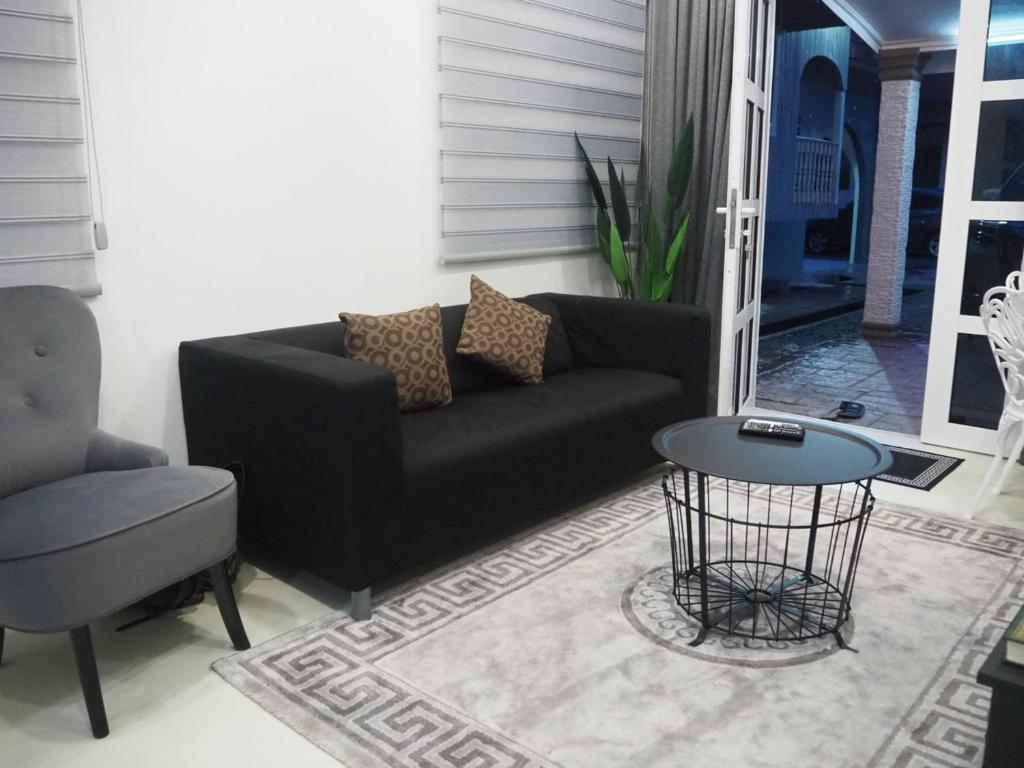 a living room with a black couch and a table at Terengganu Guest House 2 in Marang