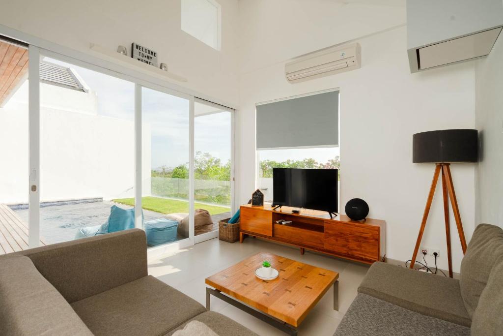 a living room with a couch and a tv at Aurelia Residence in Uluwatu