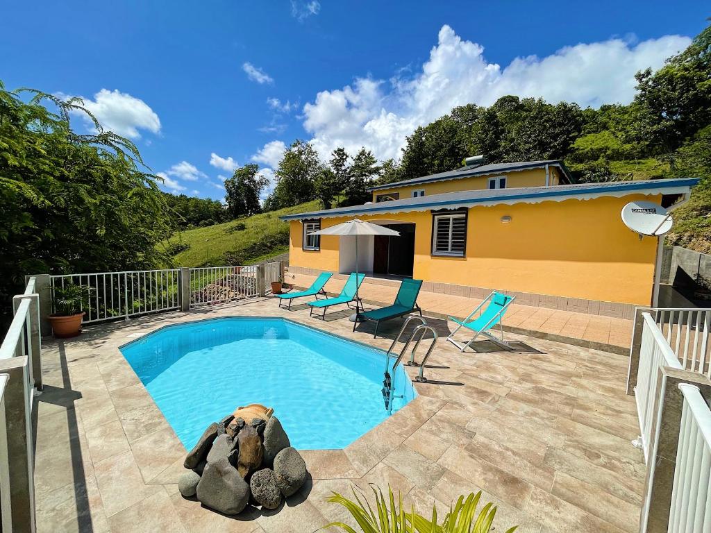 una piscina frente a una casa en La Villa Ixora, magnifique Villa avec Piscine, en Les Abymes