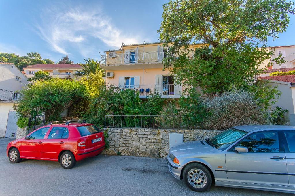 dos autos estacionados en un estacionamiento frente a un edificio en Apartment Town View en Korčula