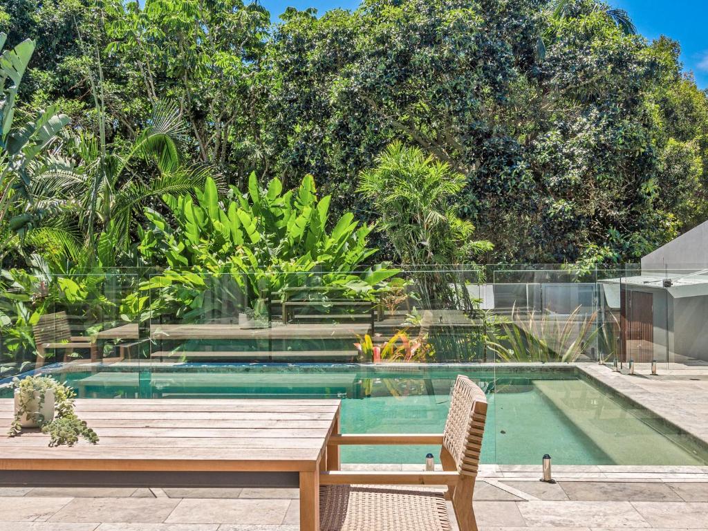 una piscina con una mesa de madera y un banco en Stonecutters1, en Byron Bay