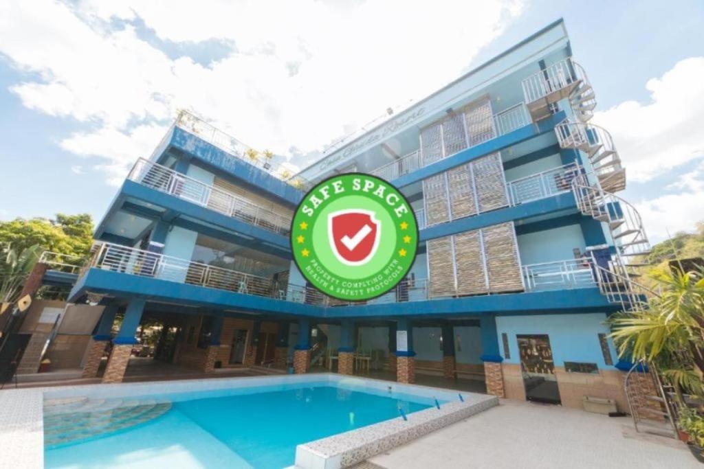 a hotel with a swimming pool in front of a building at RedDoorz Premium @ Casa Ghilda Resort Olongapo City in Olongapo
