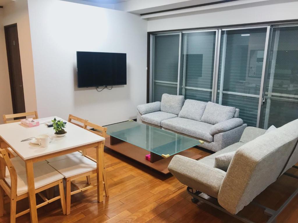 a living room with a couch and a table at PRISM COURT 綾瀬 in Tokyo