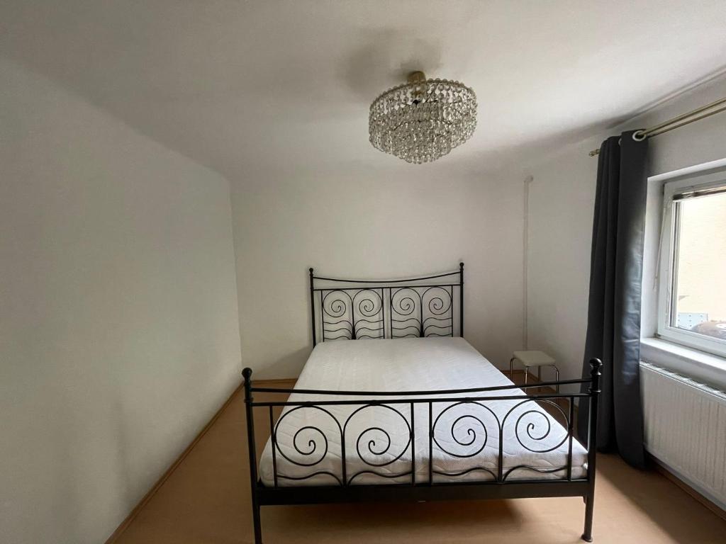 1 dormitorio con cama y lámpara de araña en Große Wohnung zum Wohlfühlen, 