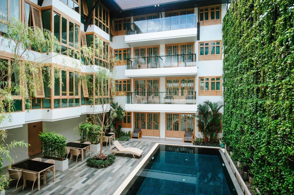 an exterior view of a building with a swimming pool at Moon Dragon Hotel in Chiang Mai