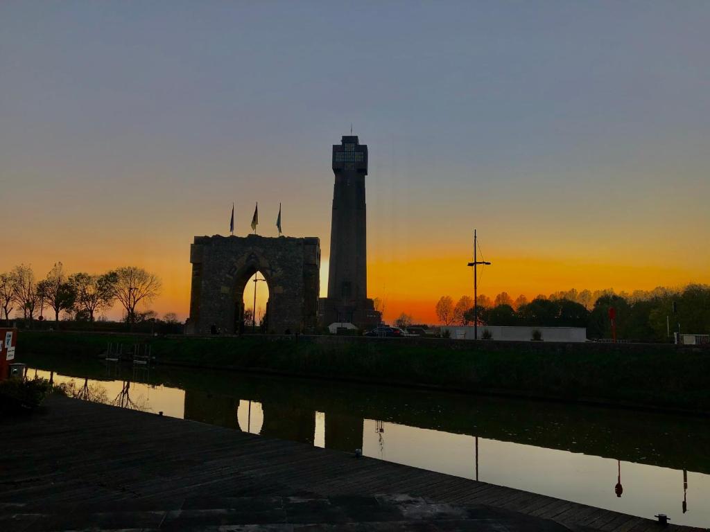 um monumento com uma torre de relógio ao pôr-do-sol em Vakantiehuisje aan de Ijzer em Diksmuide