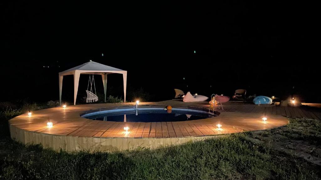 a circular pool with lights around it at night at Wings of Tatev Private Villa in Halidzor