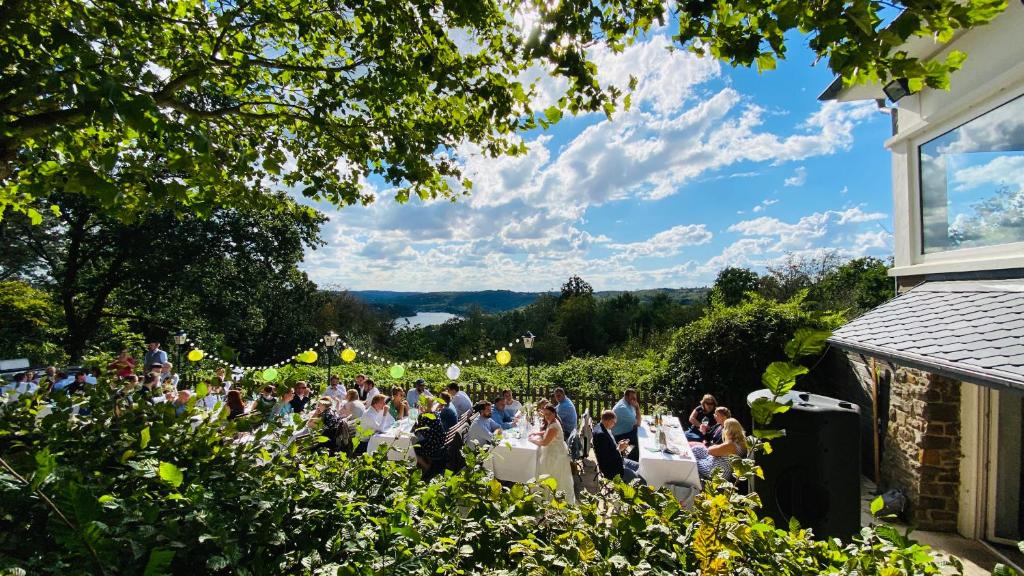 un grupo de personas sentadas en mesas en un jardín en Pension Heimliche Liebe en Essen