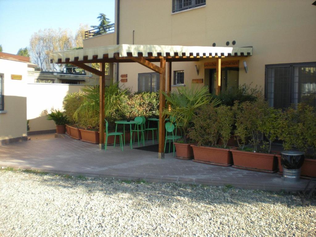 ボローニャにあるBassini Residenceの建物の前に植物が植えられたパティオ(椅子付)