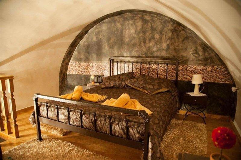 ein Schlafzimmer mit einem großen Bett und einer gewölbten Decke in der Unterkunft Despotikon Dimitsana Guest house - Ξενώνας Δεσποτικόν Αντωνόπουλου in Dimitsana