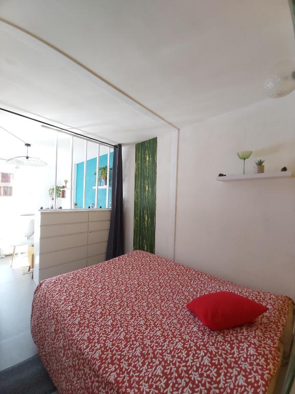 a bedroom with a red bed with a red pillow at Luz St Sauveur, Appartement 3 personnes, vue montagne, exposé sud, Résidence très calme in Luz-Saint-Sauveur