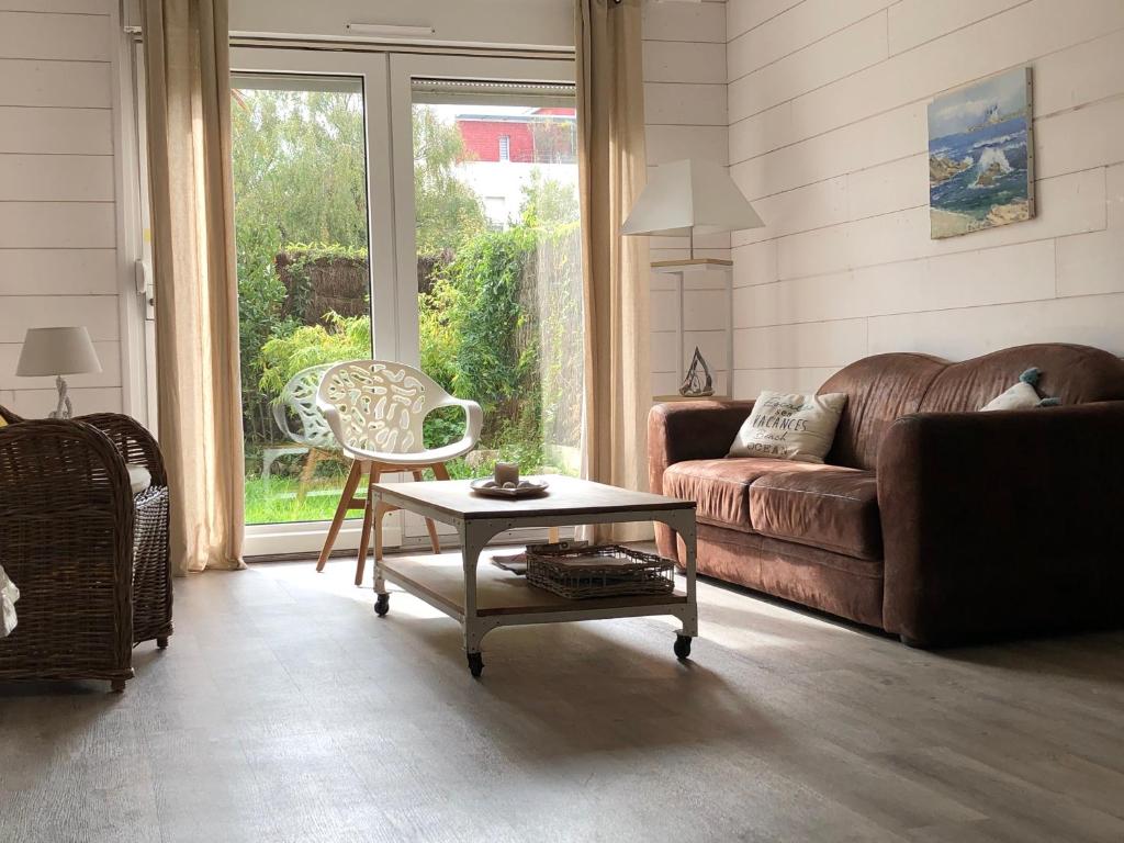 un salon avec un canapé et une table dans l'établissement Bel appartement en rez-de-jardin à 100m des plages, à Saint-Nazaire