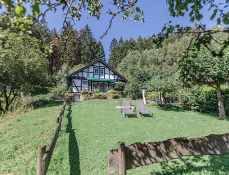 a house with two chairs in a yard at Haus Felsberg in Niedersalwey