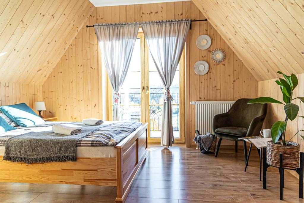 a bedroom with a bed and a large window at Farmerska Chata in Czarna Góra