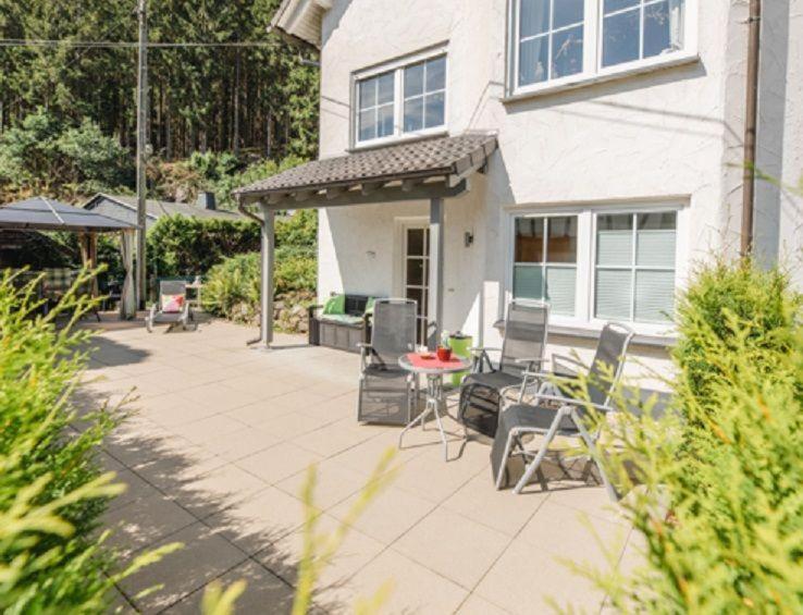 a patio with chairs and a table in front of a house at Haus Salweyblick in Niedersalwey