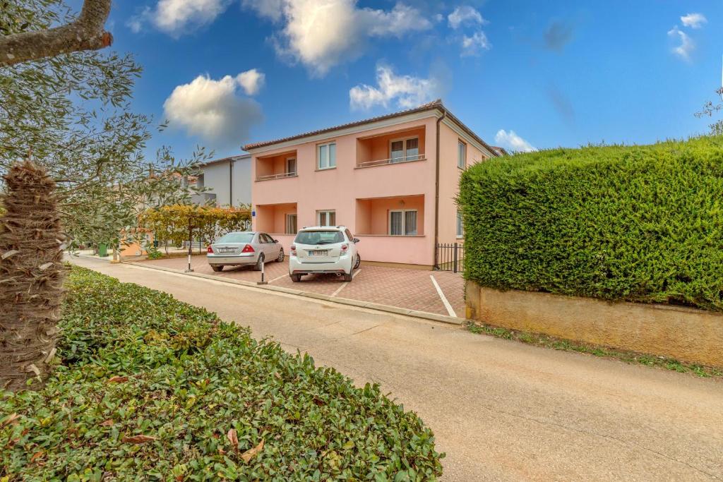 a house with two cars parked in front of it at Apartments Alen in Fažana