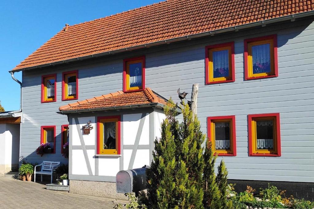 Casa blanca con ventanas rojas y amarillas en Ferienwohnung Riemer en Geisa