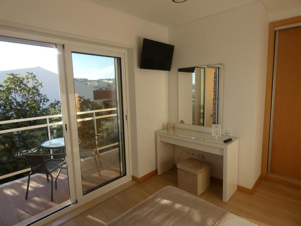 a room with a mirror and a table and a balcony at Villa Barrinha in Praia de Mira