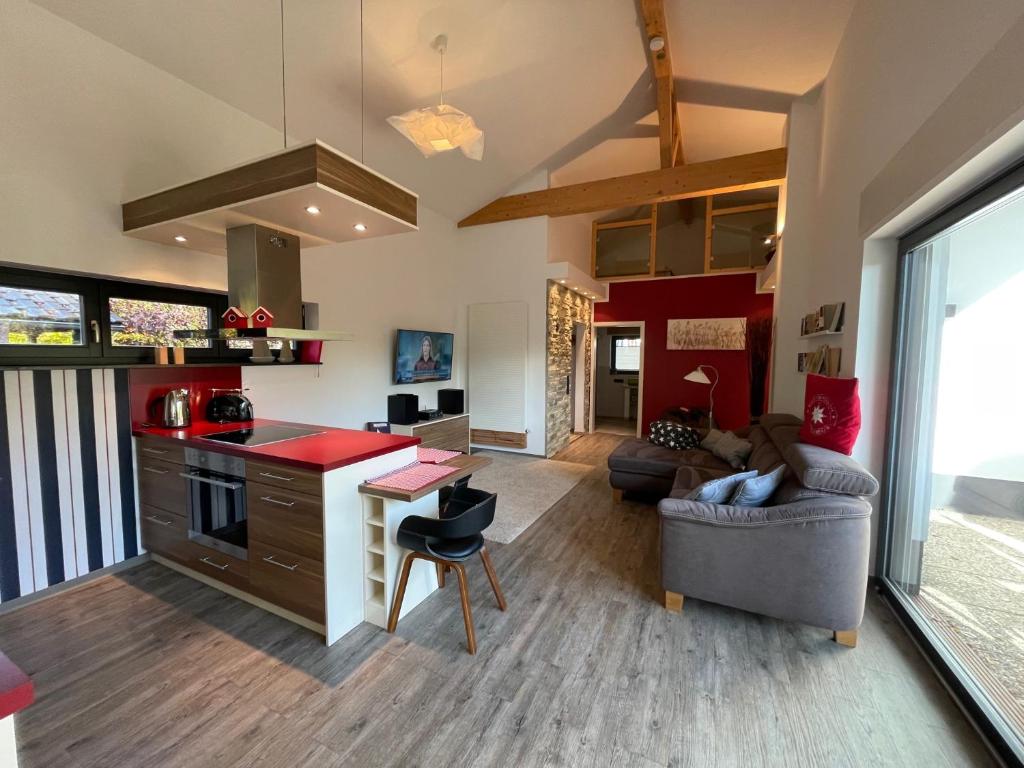 eine Küche und ein Wohnzimmer mit einem Sofa und einem Tisch in der Unterkunft Sailhouse Edersee in Edersee