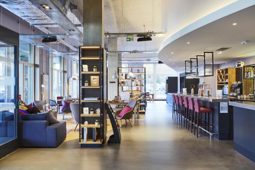 een lobby van een winkel met stoelen en een bar bij Campanile Paris Sud Saclay- Gif sur yvette in Saclay