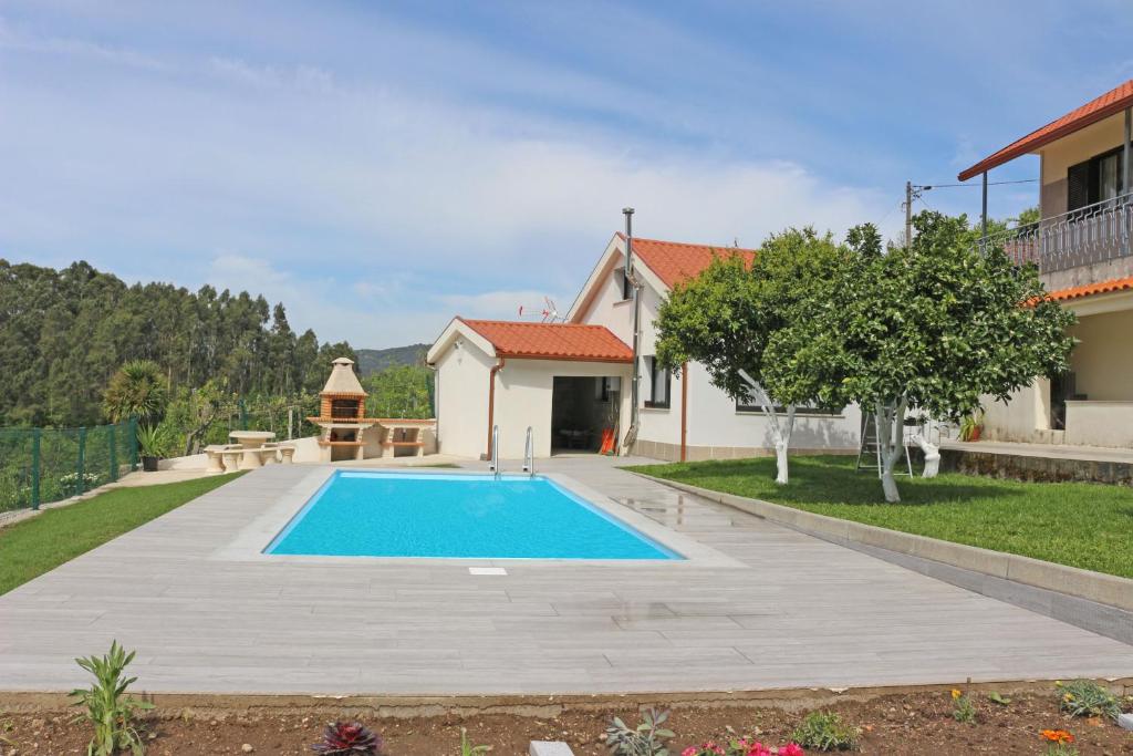 eine Villa mit Swimmingpool und ein Haus in der Unterkunft Casa das Laranjeiras by Gerês Casas in Carvalheira