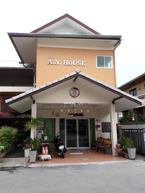 a building with an am house with a motorcycle outside at A.N. HOUSE in Chiang Mai