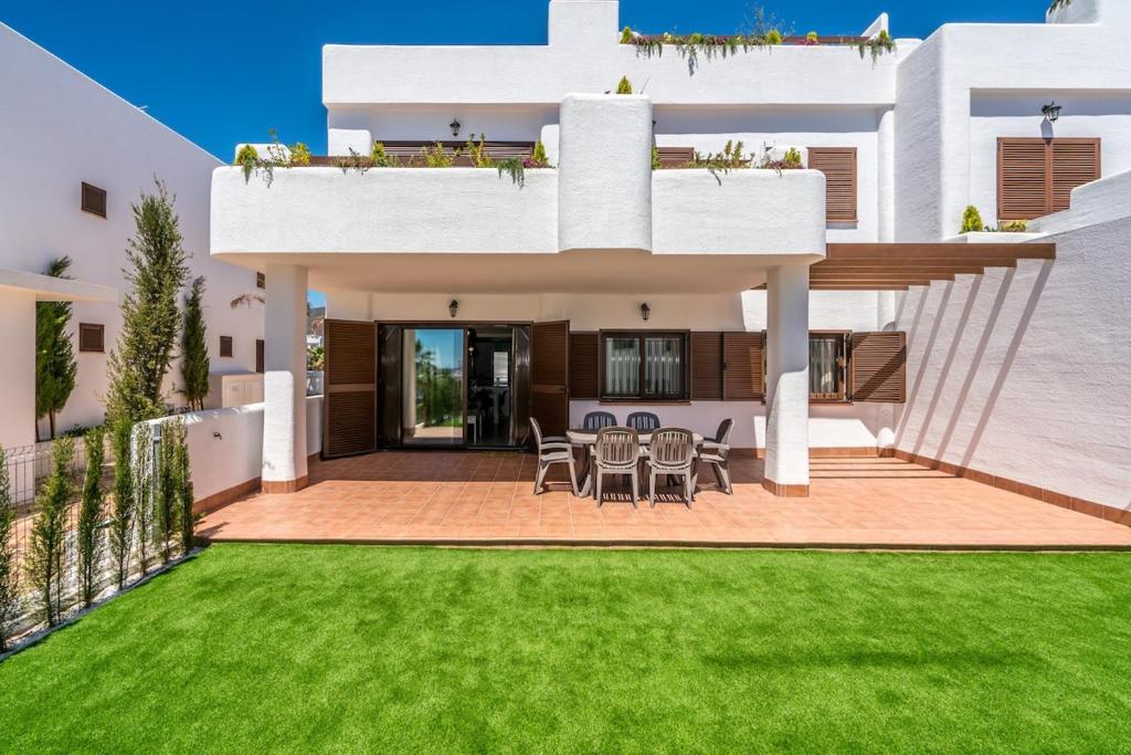 a white house with a lawn in front of it at Higos in San Juan de los Terreros
