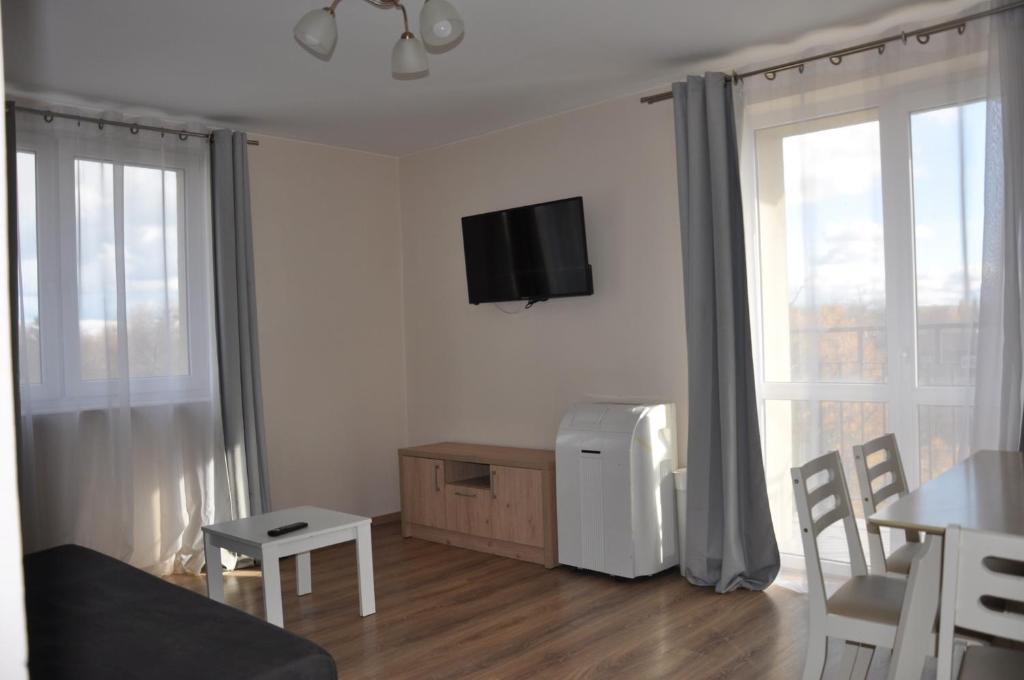 a living room with a tv on the wall at ESEN Apartamenty Akademicka in Białystok