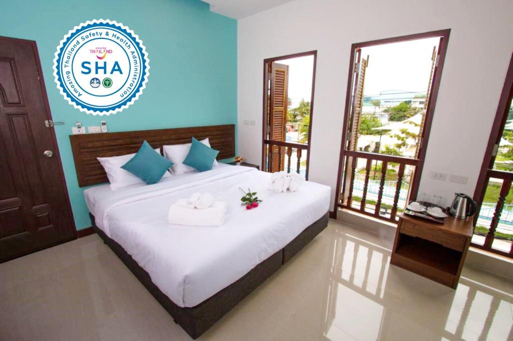 1 dormitorio con 1 cama con toallas en BS Airport at Phuket en Nai Yang Beach