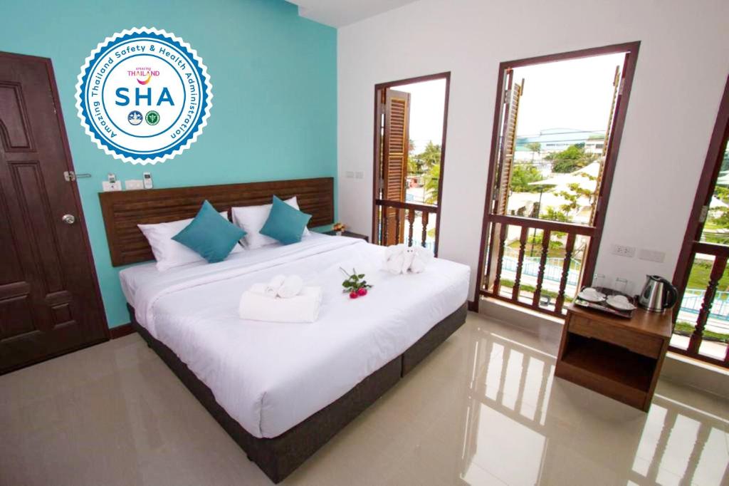 a bedroom with a bed with towels on it at BS Airport at Phuket in Nai Yang Beach