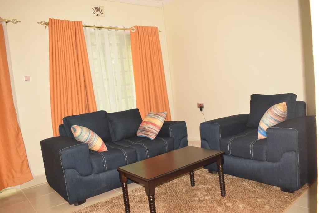 Sala de estar con 2 sofás azules y mesa de centro en Stylish 2BR with Wi-Fi and secure parking, en Kakamega