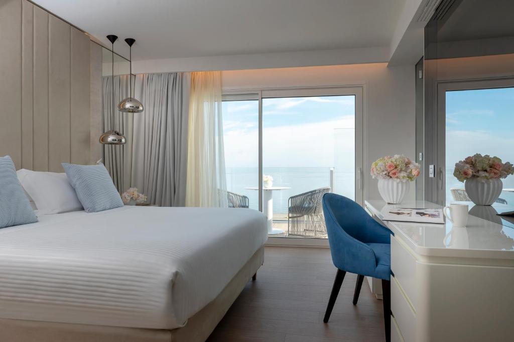 a hotel room with a bed and a desk and a window at Hotel Atlantic in Riccione