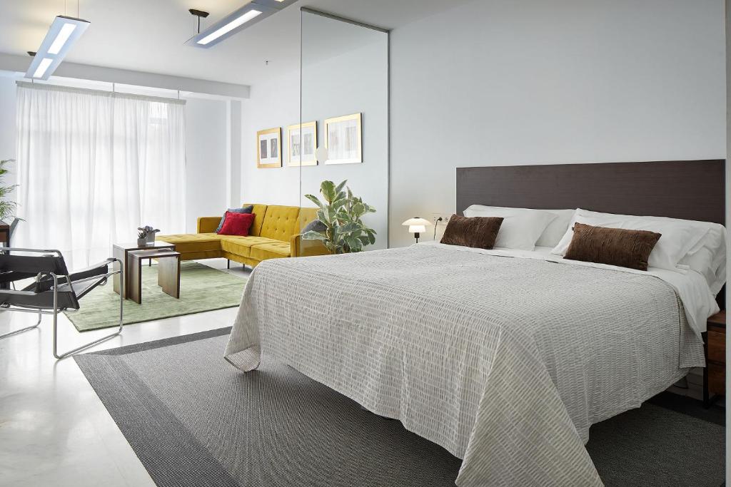a bedroom with a large bed and a living room at Satori Suites in San Sebastián
