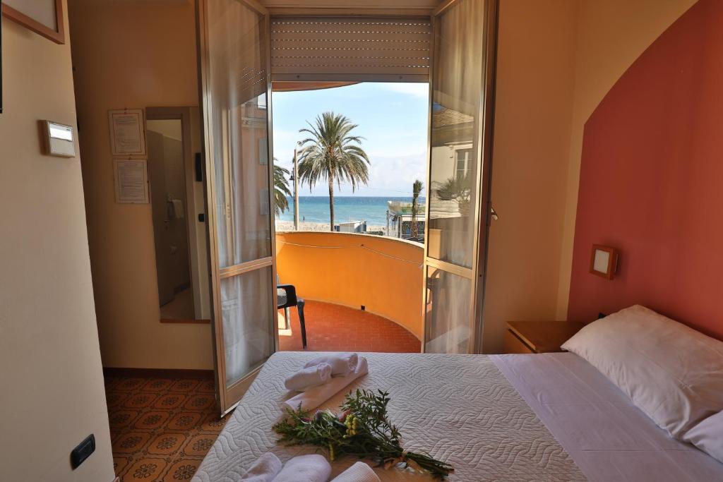 um quarto com uma cama e vista para o oceano em XXV APRILE Casa per Ferie em Albenga