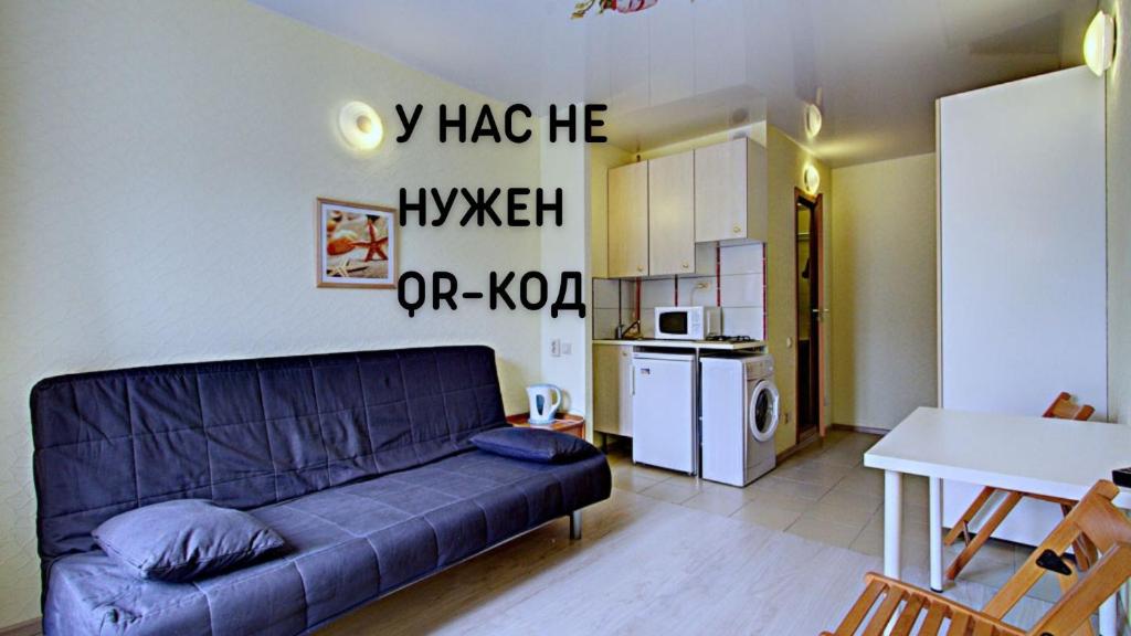 a living room with a couch and a kitchen at STN ApartHotel on Grafsky in Saint Petersburg