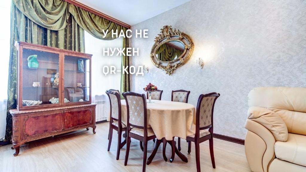 uma sala de jantar com mesa e cadeiras em Апартаменты на канале Грибоедова em São Petersburgo