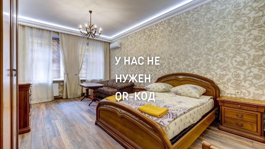 a bedroom with a bed with a sign on the wall at STN on Karavannaya in Saint Petersburg