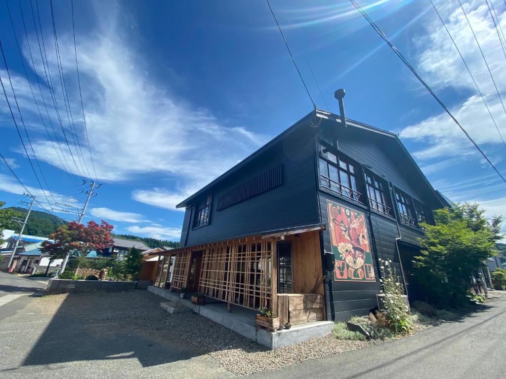 ein schwarzes Gebäude mit Gemälden auf der Seite in der Unterkunft yuzaka - natural & sustainable inn - in Kazuno