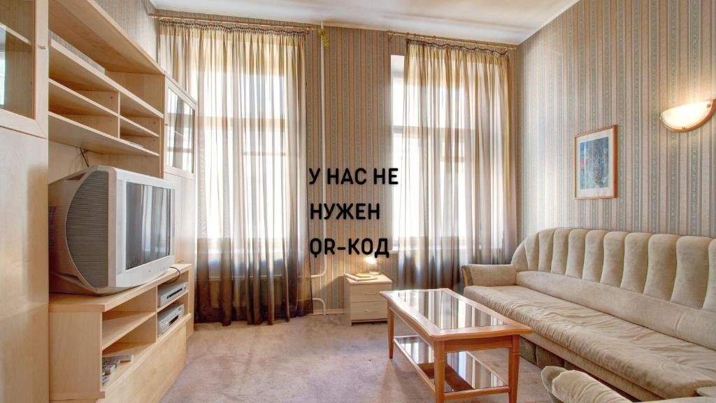 a living room with a couch and a tv at STN Apartments Budget in Saint Petersburg