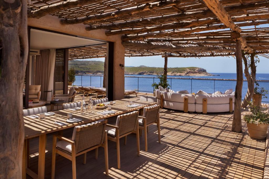 a dining room with a table and chairs and the ocean at Six Senses Ibiza in Portinatx
