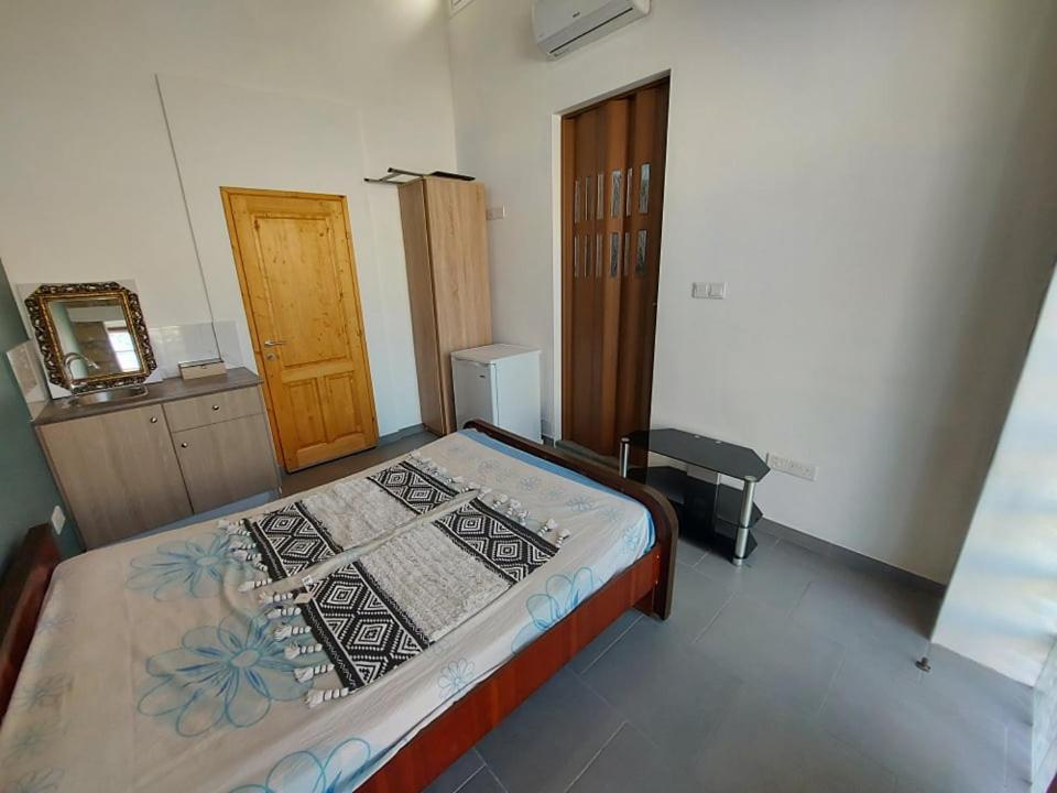 a bedroom with a bed and a wooden door at Anna Guesthouse 10 min walk from the beach in Larnaca