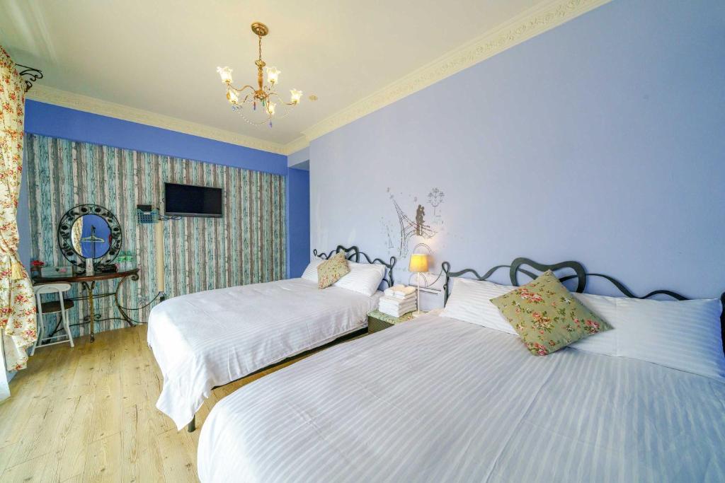 two beds in a bedroom with blue walls at YuanWai in Wujie