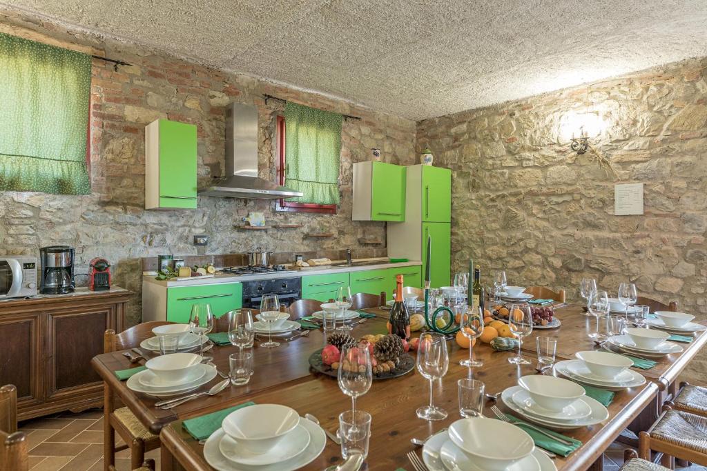 een keuken met een houten tafel en groene kasten bij PODERE SAN ANSANO 14&2, Emma Villas in Paganico