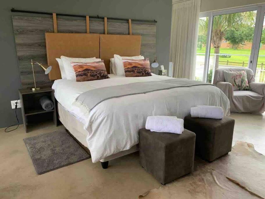 - une chambre avec un grand lit et une grande fenêtre dans l'établissement The Studio on Cordia DSTV WIFI 2km from Umhlanga Beach, à Durban